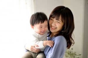 赤ちゃんとほほえむママ